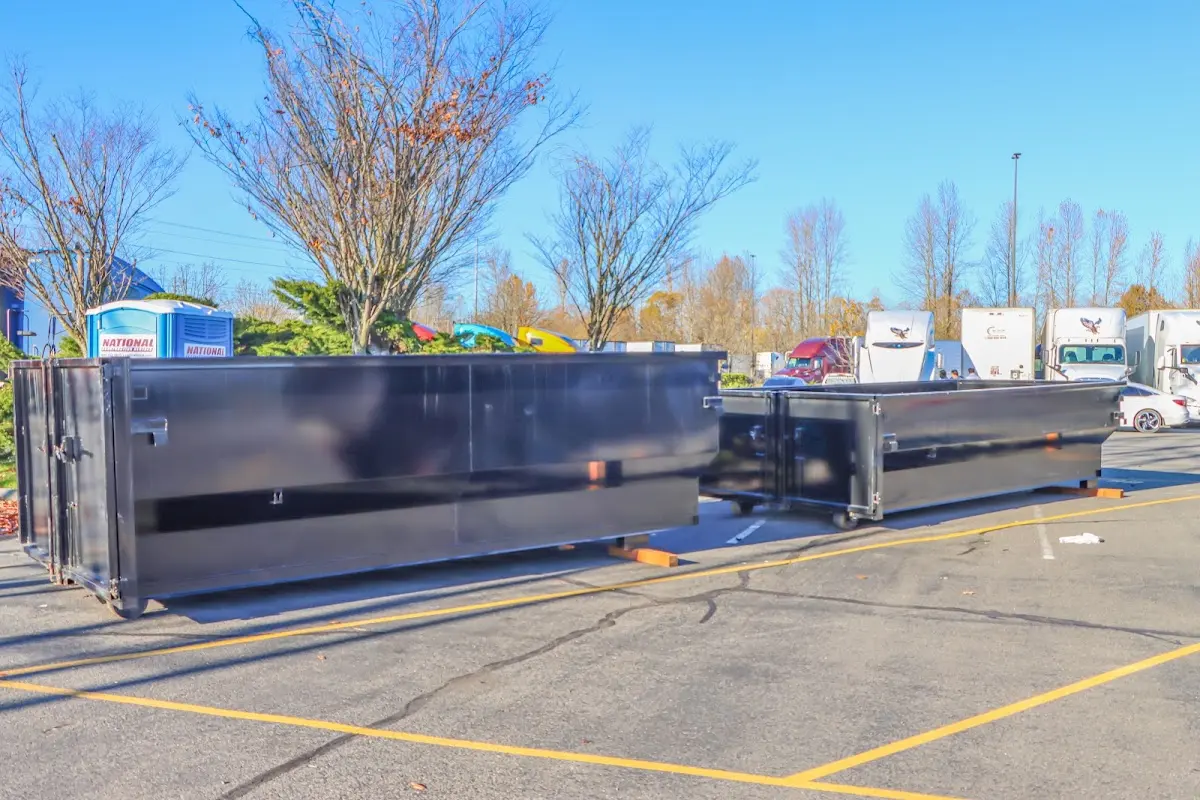 Professional dumpster rental service with roll-off container on residential driveway in Goshen